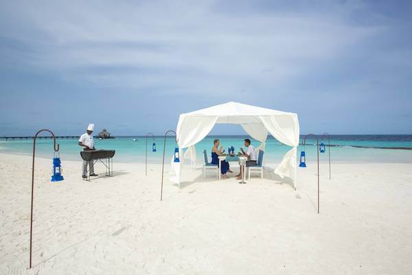 Paar bei einem Grill auf dem Strand vor dem Reethi Beach Resort