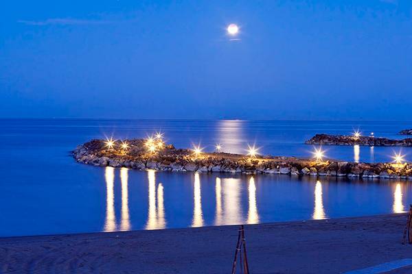 Nachtansicht des Knossos Strandes mit Mond und Lichtern