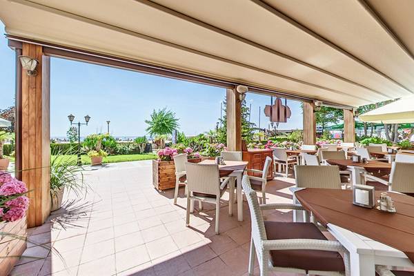 Außenterrasse des Bellevue Hotels mit Tischen, Stühlen und Pflanzen im Freien.