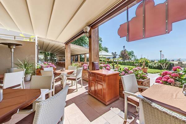 Terrasse des Bellevue Hotels mit Tischen, Stühlen und Blumenarrangements.