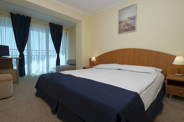 Schlafzimmer im Bellevue Hotel mit Doppelbett, Nachttischen und Lampen.