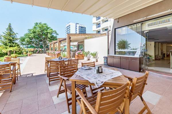Außenterrasse des Bellevue Hotels mit Tischen, Stühlen und Pflanzen.