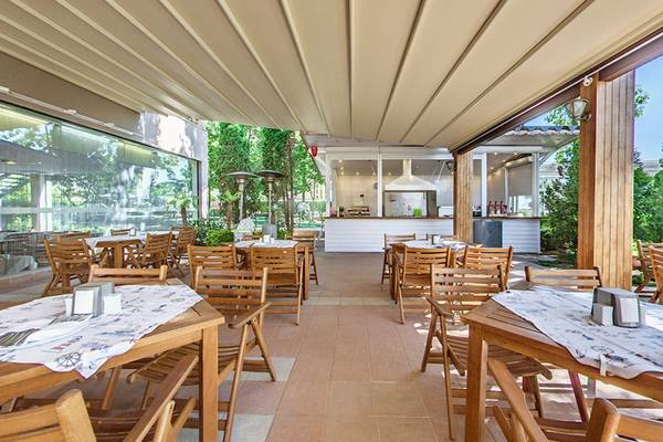 Terrasse des Bellevue Hotels mit braunen Holztischen und Stühlen.