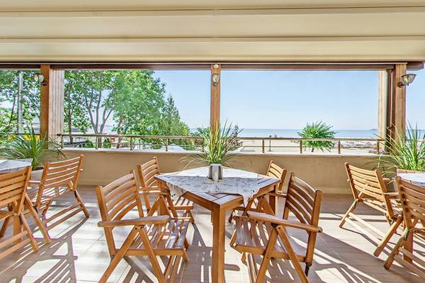 Terrasse des Bellevue Hotels mit Blick auf das Meer und Bäume.