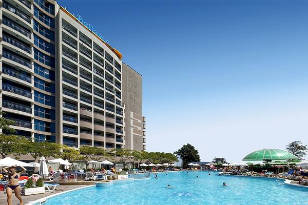 Außenansicht des Bellevue Hotels mit großem Pool und vielen Gästen, die sich entspannen.
