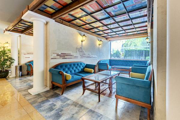 Innenansicht der Lobby des Bellevue Hotels mit blauen Sofas und einem Glastisch.