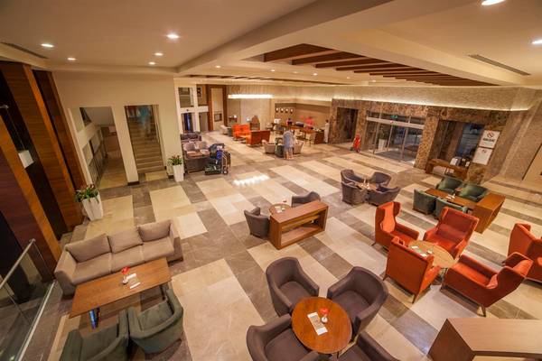 Innenansicht der Lobby des Arcanus Side Resort Hotels mit Sitzgelegenheiten und Rezeption.