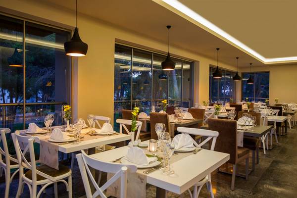 Innenansicht des Restaurants im Arcanus Side Resort mit gedeckten Tischen und Stühlen.