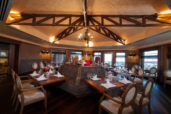 Innenansicht des Restaurants im Arcanus Side Resort mit geometrischer Decke und gedeckten Tischen.