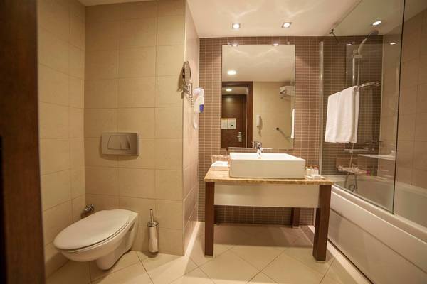 Ein modernes Badezimmer im Arcanus Side Resort mit Badewanne, Dusche, Spiegel und Waschbecken.