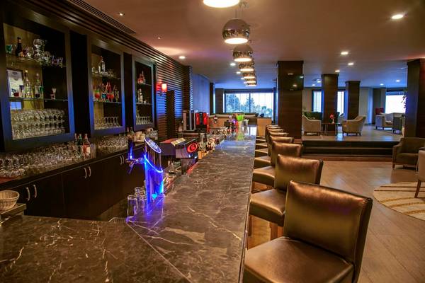 Bar im Arcanus Side Resort Hotel mit Marmortheke und Lederstühlen.