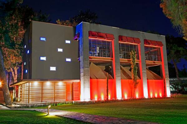 Arcanus Side Resort Hotel bei Nacht mit roten und blauen Lichtern.