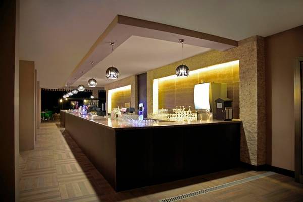 Innenansicht der Bar im Arcanus Side Resort Hotel mit Theke und Beleuchtung.