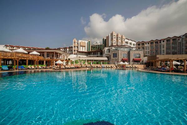 Außenpool des Arcanus Side Resort Hotels mit vielen Liegestühlen und Sonnenschirmen.