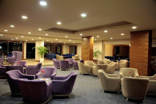 Lobby-Bereich des Arcanus Side Resort mit vielen violetten und beigefarbenen Sesseln.