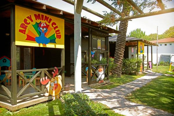 Außenbereich des Arcanus Side Resort Mini Clubs mit bunten Gebäuden und Spielsachen.