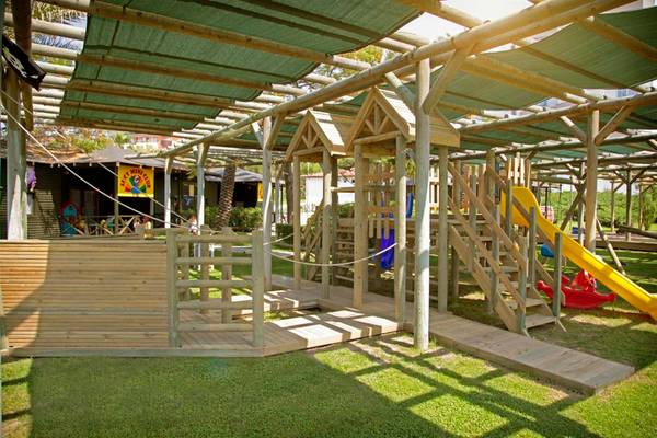 Kinderspielplatz im Arcanus Side Resort mit Holzspielzeug und Rutsche.