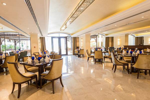 Innenbereich eines eleganten Restaurants im Marjan Island Resort & Spa mit gedeckten Tischen und Stühlen.
