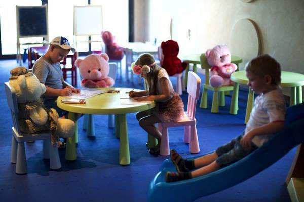 Kinder im Spielzimmer des Marjan Island Resort & Spa, das mit weichen Teppichböden und bunten Möbeln ausgestattet ist.