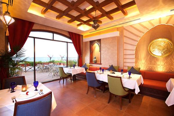 Innenansicht des Marjan Island Resort & Spa Restaurants mit Tisch und Stuhl, Blick auf den Ozean
