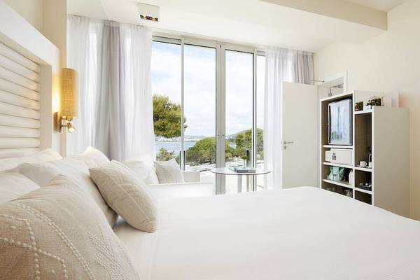 Innenansicht eines Zimmers im ME Ibiza Hotel mit Blick auf den Ozean.