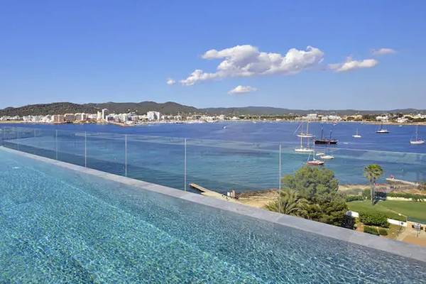 Außenpool des ME Ibiza Hotels mit Blick auf das Meer und die Stadt.