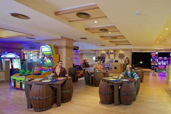 Arcade-Bereich im Marjan Island Resort & Spa mit Holztischen und Attraktionen.