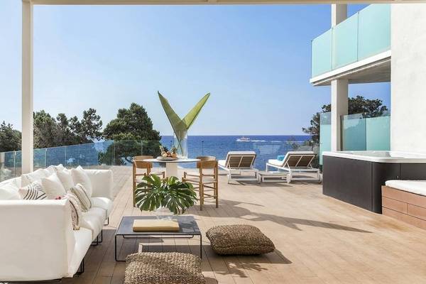 Terrasse des ME Ibiza Hotels mit Blick auf das Meer, Loungemöbel und Pflanzen