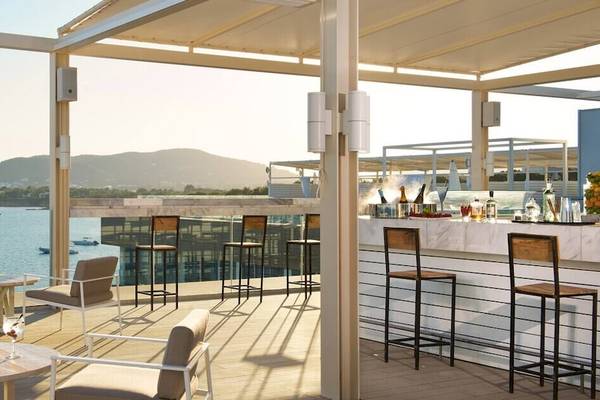 Dachterrasse des ME Ibiza Hotels mit Blick auf das Meer und die Berge.