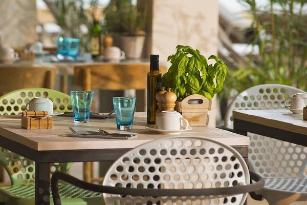 Restauranttisch im ME Ibiza Hotel mit grünen Stühlen und Holztisch.
