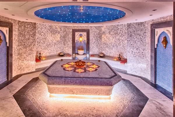 Innenansicht der Sauna im Marjan Island Resort & Spa mit beleuchteter Decke und Kerzen.