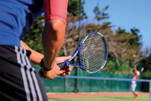 Tennisspieler auf dem Platz im Dinarobin Beachcomber Golf Resort & Spa