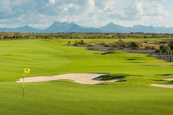 Golfplatz im Dinarobin Beachcomber Golf Resort & Spa mit grünen Fairways, Bunker und blauem Himmel mit Wolken