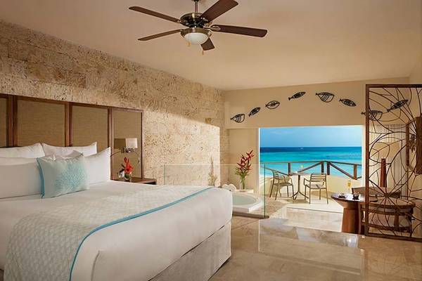 Ein Luxus-Schlafzimmer im Impressive Premium Punta Cana mit Blick auf das Meer und einer Badewanne auf dem Balkon.