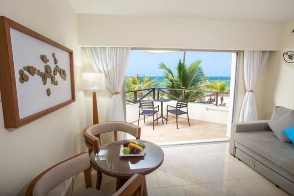 Wohnzimmer des Impressive Premium Punta Cana Hotels mit Blick auf Terrasse und Meer.