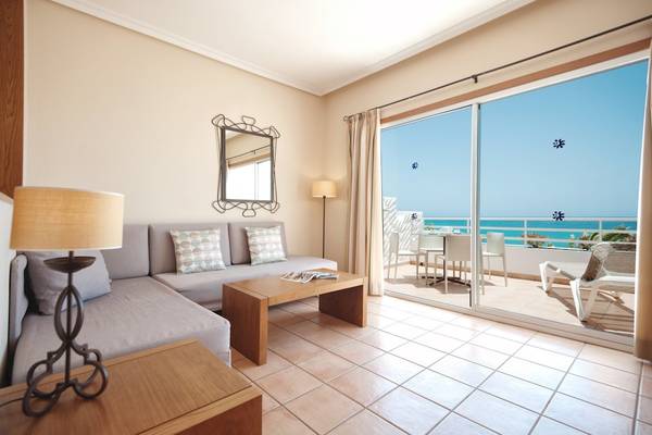 Wohnzimmer des Sotavento Beach Clubs mit Blick auf das Meer und eine Terrasse mit Möbeln