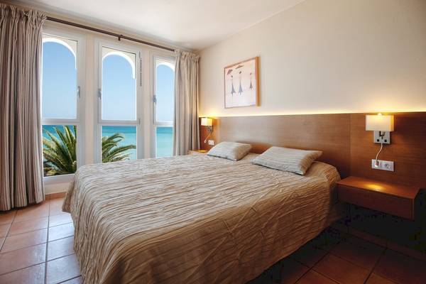 Bett im Zimmer des Sotavento Beach Club Hotels mit Blick auf das Meer.