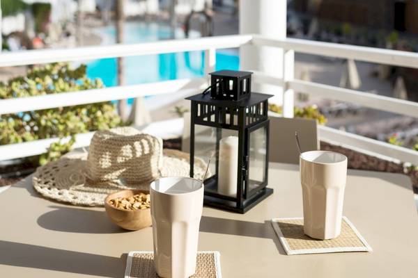 Tisch auf dem Balkon des Sotavento Beach Club mit zwei Gläsern, einem Teelicht, einer Hut und einer Schüssel mit Nüssen.