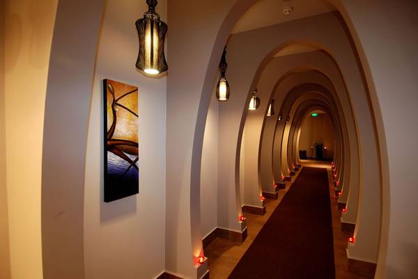 Korridor des Botanik Platinum Hotels mit roten Kerzen und Gemälde an der Wand.