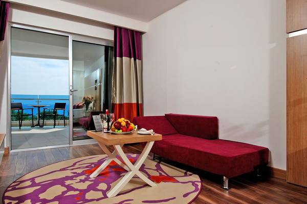 Rotes Zimmer im Botanik Platinum Hotel mit Tisch, Früchten und Meerblick.