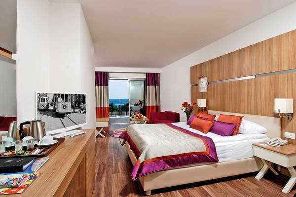 Hotelbett in einem Zimmer mit Balkon und Blick auf die Stadt