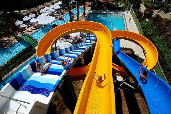 Kinder rutschen auf den Wasserrutschen im Botanik Platinum Hotel.