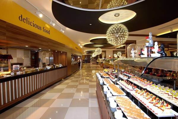 Innenansicht des Restaurants des Botanik Platinum Hotels mit einer langen Theke voller Desserts und Buffets.