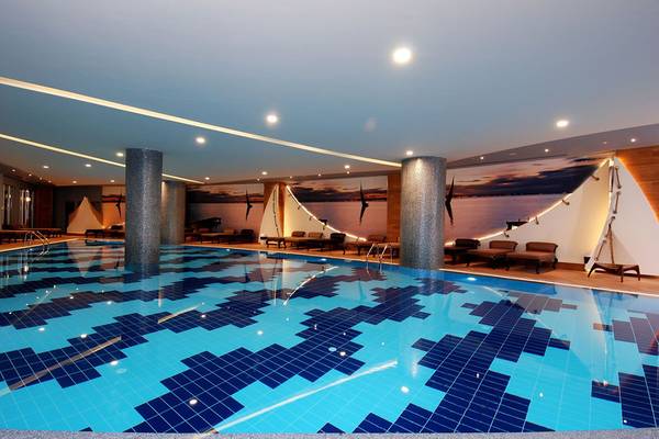 Innenpool im Botanik Platinum Hotel mit blauen Fliesen und Lounge-Bereich