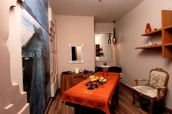 Massageraum im Botanik Platinum Hotel mit Behandlungstisch, Wandmalerei und Dekor.
