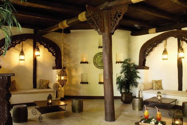 Innenbereich des Breezes Beach Club & Spa Zanzibar mit Möbeln, Pflanzen und Lampen.