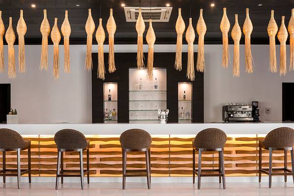 Barbereich des Mitsis Faliraki Beach Hotel & Spa mit modernen Stühlen und goldfarbenen Beleuchtungselementen
