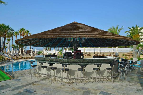 Bar am Pool im Golden Bay Beach Hotel mit Sonnenschirm und Sonnenliegen im Hintergrund.