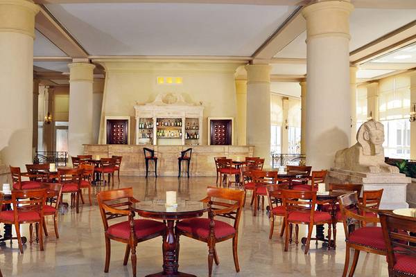 Innenbereich des Sheraton Sharm Hotel mit Säulen, Tischen und Stühlen.