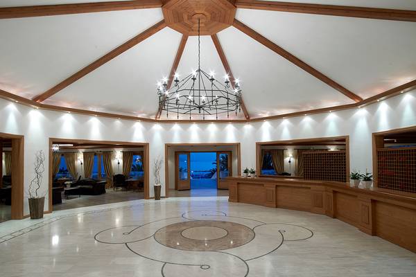 Lobby des Mitsis Rinela Beach Hotels mit Kronleuchter und Marmorboden.